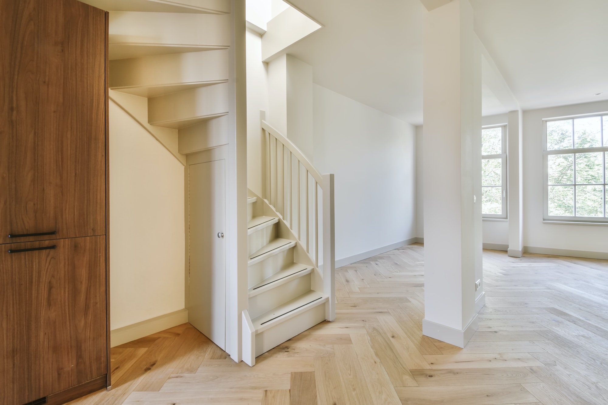 Wooden semi spiral staircase with parquet flooring in the hall